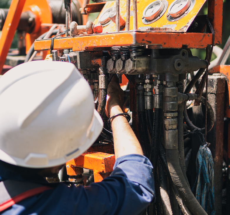 technician inspecting heavy machinery for hydraulic leaks